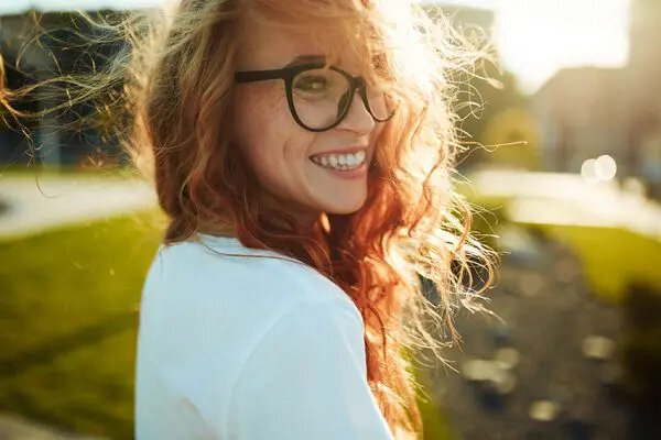 cute red haired woman walks in the sunlight