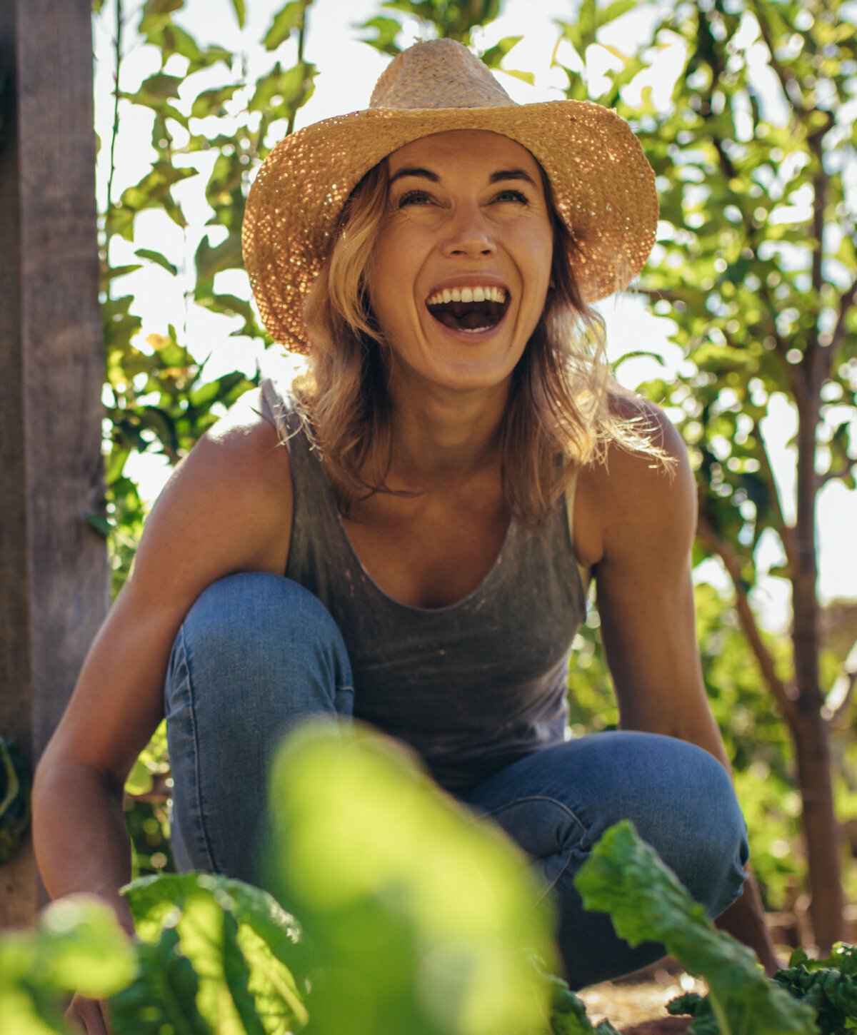 river edge preventative dentistry model laughing and wearing a sun hat and overalls