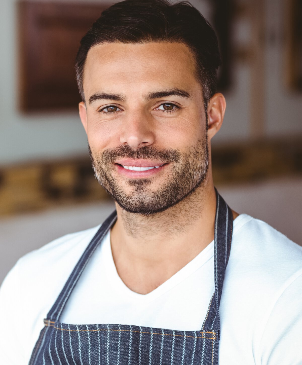 male dental services patient model wearing a blue apron and smiling
