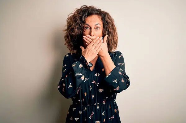 cosmetic dentistry patient model covering her mouth with her hands