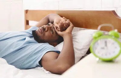 sleep apnea patient model laying in bed with he arms above his head