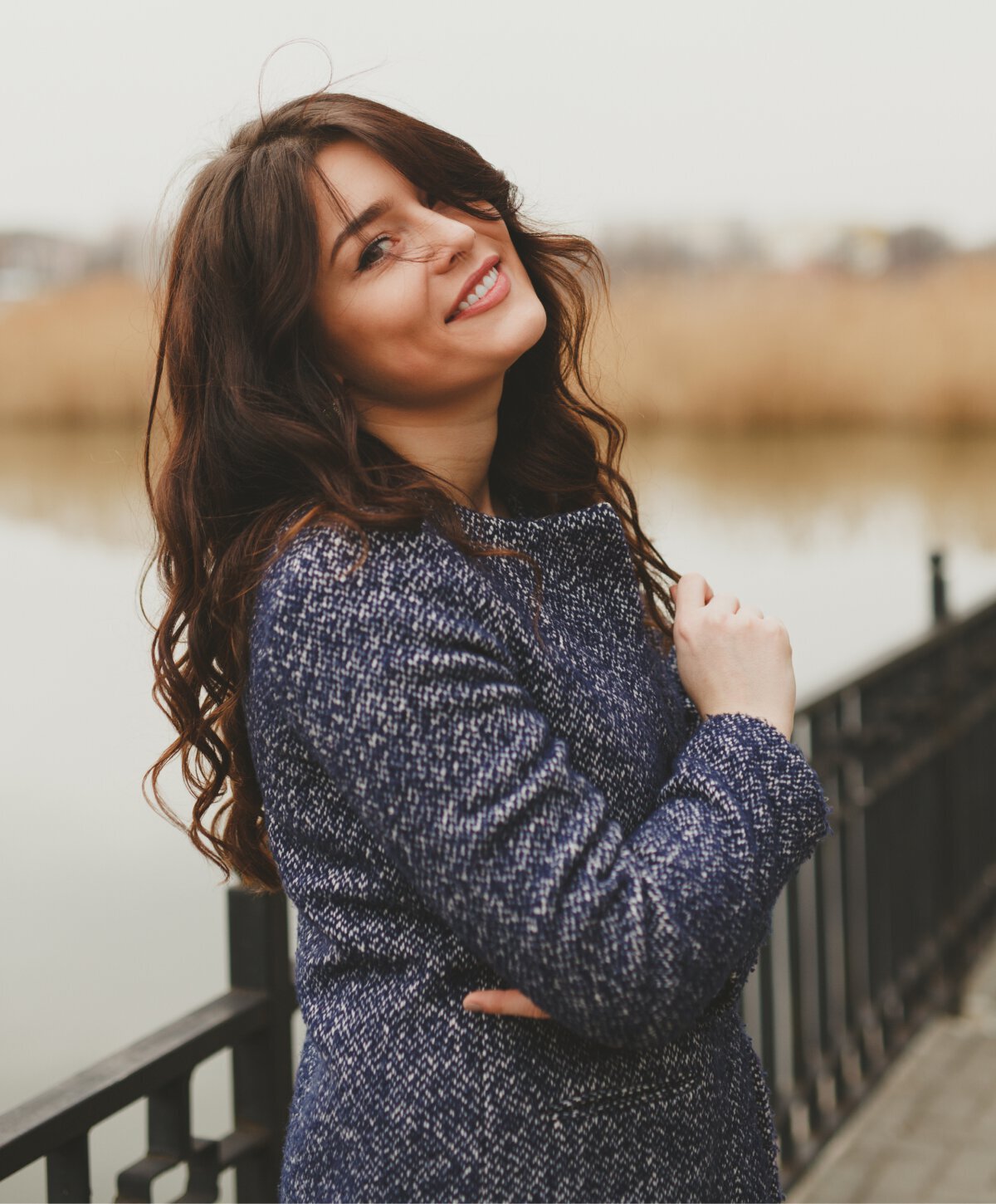 river edge smile makeover patient model smiling with brown hair and a blue coat