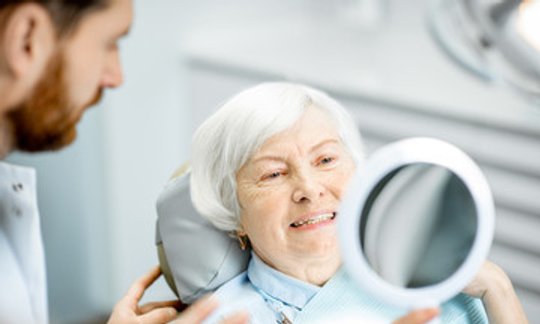 Dentist reviewing All-on-4 dental implant scans with a patient