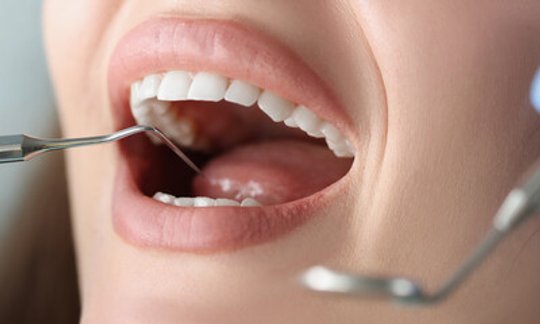 Woman smiling confidently after cosmetic dentistry consultation with healthy gums